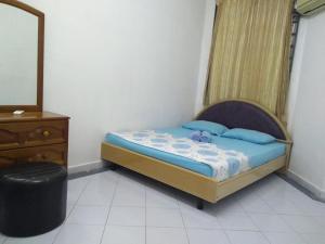 1 dormitorio con cama, tocador y espejo en Rumah Tamu AZ Pasir Tumboh, en Kampong Binjai