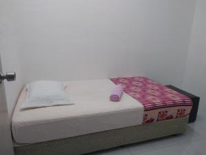 a small bed sitting in a room with at Rumah Tamu AZ Pasir Tumboh in Kampong Binjai