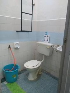 y baño con aseo, lavamanos y cubo. en Rumah Tamu AZ Pasir Tumboh, en Kampong Binjai