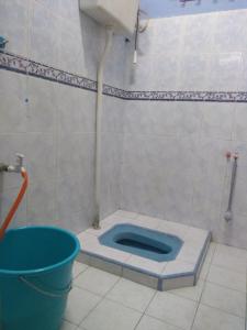 baño con aseo azul en el suelo en Rumah Tamu AZ Pasir Tumboh, en Kampong Binjai