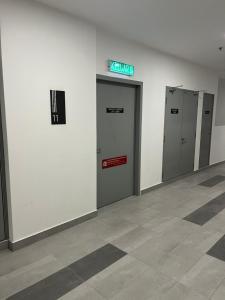 un couloir avec trois ascenseurs dans un bâtiment dans l'établissement New Cozy Mvista Homestay at Bayan Lepas Factory Area, à Bayan Lepas