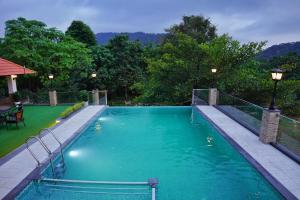 una piscina con acqua blu in un cortile di Athirappilly Rainland Resort a Athirappilly