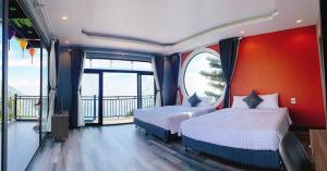 Vĩnh PhúcにあるSunset Villa Tam Dao - Venuestayのベッドルーム1室(ベッド2台付)、バルコニーが備わります。