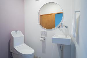 a bathroom with a mirror and a toilet and a sink at Aica TABI-NE in Kanazawa