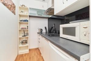 a kitchen with white cabinets and a microwave at Rynek Apartment The Heart of the City by Renters in Wrocław