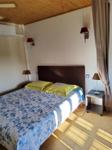 a bedroom with a bed with a blue comforter at Le clos d'André in Castelnaudary