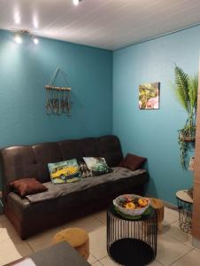 sala de estar con sofá marrón y pared azul en La chambre d Angeline en Foy-Notre-Dame