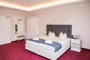 a bedroom with a large bed with a red carpet at Stadtperle Rostock in Rostock