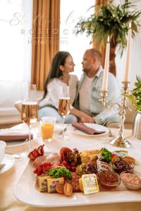 un homme et une femme assis à une table avec une assiette de nourriture dans l'établissement Stadtperle Rostock, à Rostock