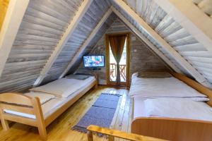 a bedroom with two beds in a attic at Fruškogorski apartmani in Čerević