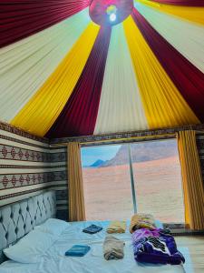 a bed in a tent with a view of the desert at Wadi Rum Cave Camp &Jeep Tour in Wadi Rum