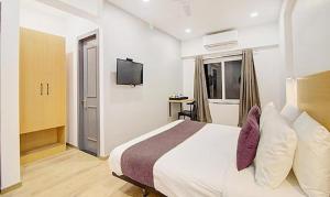 a hotel room with a bed and a television at FabHotel Ashray Residency in Navi Mumbai