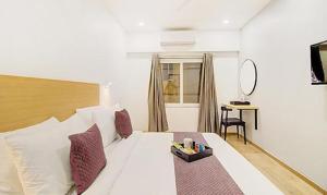 a bedroom with a large white bed and a desk at FabHotel Ashray Residency in Navi Mumbai