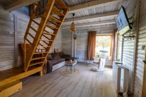 un salon avec un escalier en colimaçon dans une cabine dans l'établissement Fruškogorski apartmani, à Čerević