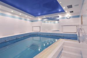 a large swimming pool with a blue ceiling at Belvedere Wellness Hotel in Mariánské Lázně