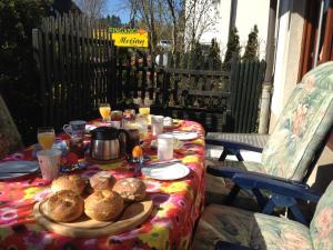 einen Tisch mit Speisen und Getränken auf einer Terrasse in der Unterkunft Haus Merian in Winterberg