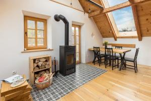 a living room with a wood stove and a table at Hiša na soncu / Sun house in Zgornje Gorje