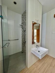 a white bathroom with a sink and a shower at Platinum Yellow Bandung Villa 24 Pax Private Pool in Bengkok