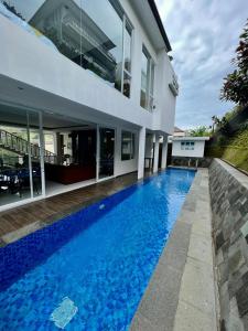 a swimming pool in front of a house at Platinum Yellow Bandung Villa 24 Pax Private Pool in Bengkok