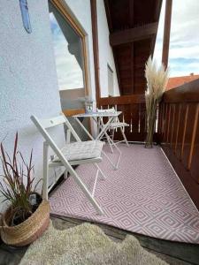 a patio with a chair and a table on a porch at Schönes Apartment in Stadtnähe Kempten (Allgäu) in Lauben