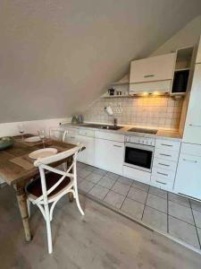 a kitchen with a table and a chair in it at Schönes Apartment in Stadtnähe Kempten (Allgäu) in Lauben