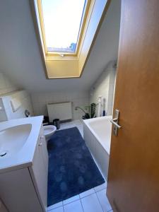 a bathroom with a sink and a tub and a skylight at Schönes Apartment in Stadtnähe Kempten (Allgäu) in Lauben