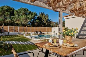 einen Tisch mit Teller mit Speisen auf der Terrasse in der Unterkunft Villa Danae Zante in Zakynthos