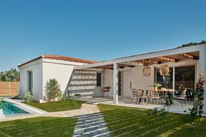 ein Haus mit einer Terrasse mit einem Tisch und einem Pool in der Unterkunft Villa Danae Zante in Zakynthos