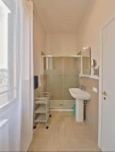 een witte badkamer met een wastafel en een douche bij Key Apartment Vatican Wall in Rome