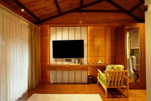 a living room with a television and a chair at Wooden ECR Sea Resort in Puducherry
