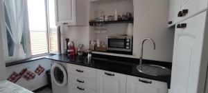 a kitchen with a sink and a washing machine at Martiri 1 by Tempovacanza in Diano Castello