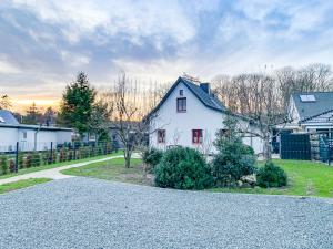 uma casa branca com uma cerca e um quintal em Ferienwohnungen und Ferienhäuser Gohr em Stralsund