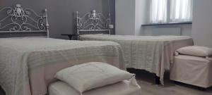 a bedroom with two beds and a chair and a window at Martiri 1 by Tempovacanza in Diano Castello