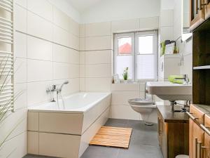 ein Badezimmer mit einer Badewanne, einem WC und einem Waschbecken in der Unterkunft Ferienwohnungen und Ferienhäuser Gohr in Stralsund