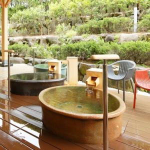 a fountain with a table and chairs in a garden at Kyukamura Noto-Chirihama in Hakui