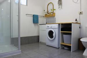 a washing machine in a bathroom with a shower at The Bunkhouse in Exmouth