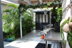 a patio with a table and chairs and plants at The Bunkhouse in Exmouth