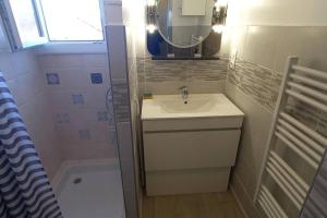 a bathroom with a sink and a mirror and a shower at Petit cocon Tarbais -wifi-parking in Tarbes