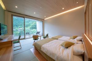 1 dormitorio con 2 camas y ventana grande en Kyukamura Oku-Musashi en Hanno