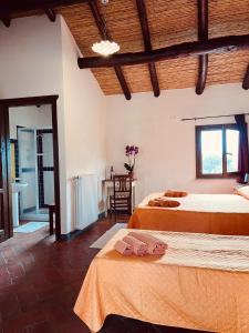Un dormitorio con 2 camas y una mesa en una habitación en Agriturismo Conca' e Janas, en Dorgali