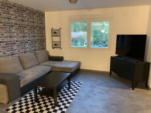 ein Wohnzimmer mit einem Sofa und einem TV in der Unterkunft Lonora paddock in Créhange