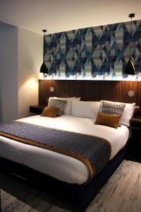 a bedroom with a large bed with a blue wall at 91 Aparthotel Jesmond Road in Newcastle upon Tyne