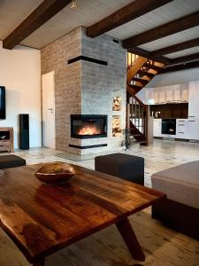 a living room with a wooden table and a fireplace at Vila Svistovka in Stará Lesná