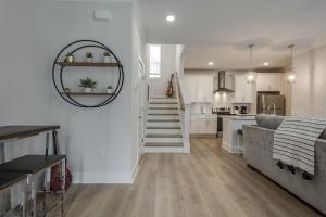 a living room and kitchen with a staircase and a couch at Classy, Cozy, Close to downtown in Nashville