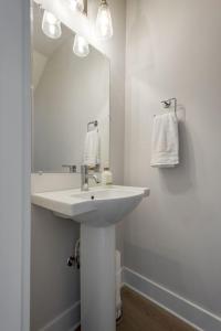 Baño blanco con lavabo y espejo en Classy, Cozy, Close to downtown, en Nashville