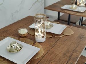 une table en bois avec des assiettes et un vase en verre dans l'établissement ROOMS alCentro, à Catane