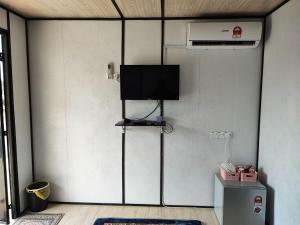 a room with a wall with a flat screen tv at Padang Besar Rainbow Cabin Homestay in Padang Besar