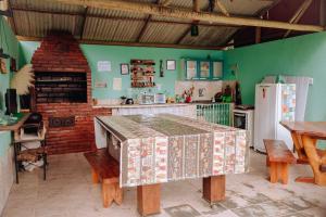 a kitchen with a table and a brick oven at Pousada & Camping Recanto dos Anjos Azuis in Paty do Alferes