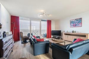 un soggiorno con divano, sedie e TV di Hello Zeeland - Appartement Port Scaldis 03-071 a Breskens