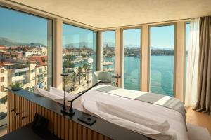 a bedroom with a bed with a view of the water at Hotel Ambasador in Split